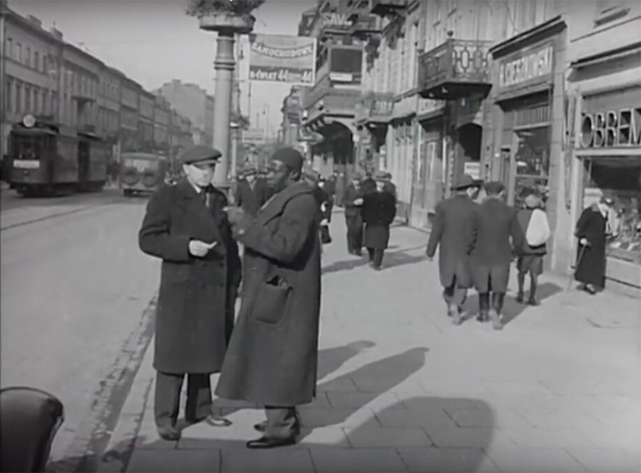 Przerwa na papierosa i pogawędkę.  Czarnoskóry portier na ul. Nowy Świat . Warszawa około 1935 roku.